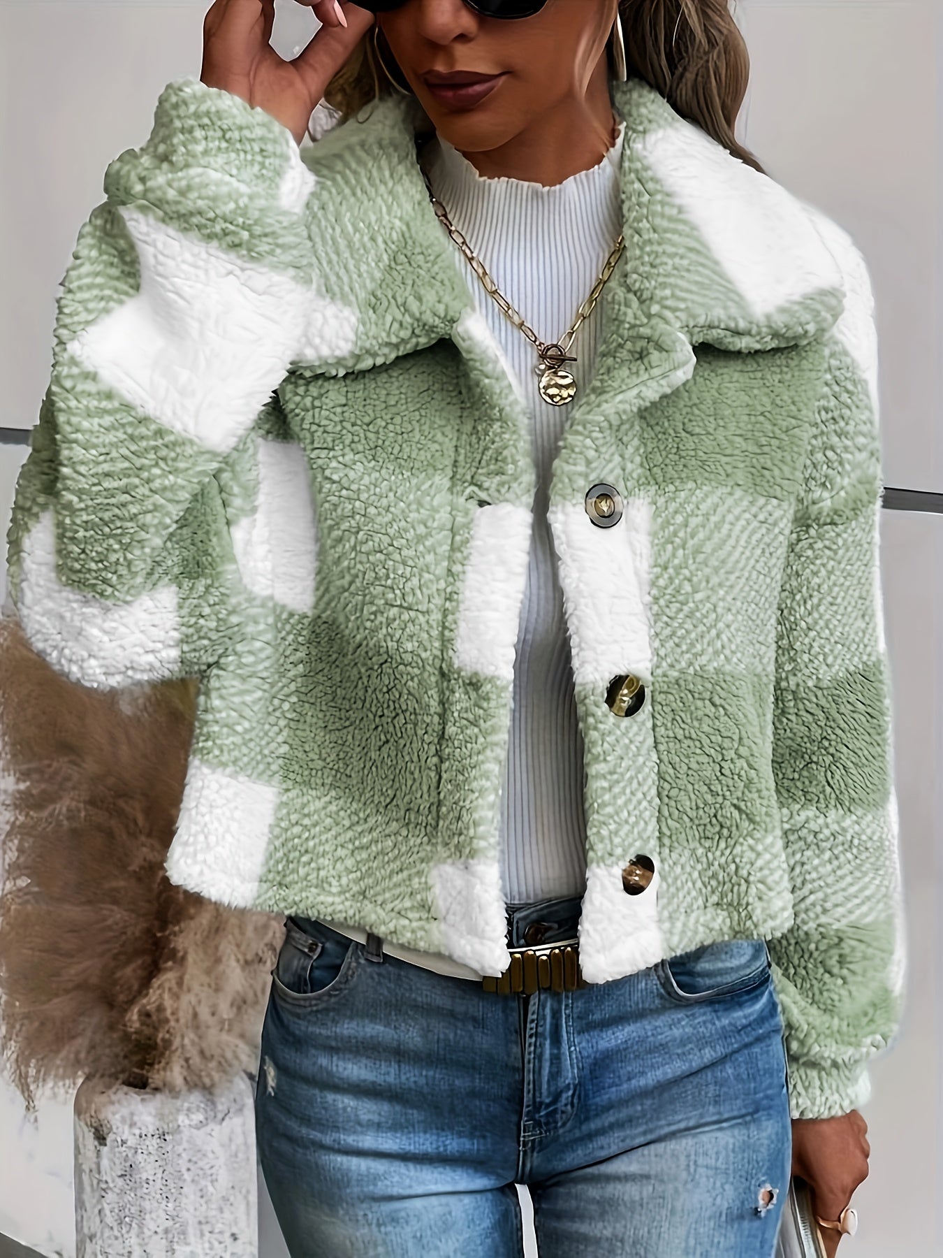 Frau trägt grün-weiß karierte Sherpa-Jacke, Jeans, modisch, Herbstmode, Damenbekleidung.