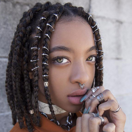 Frau mit geflochtenem Haar, silbernen Haarspangen, Nasenring, Schmuck, Vintage-Stil.