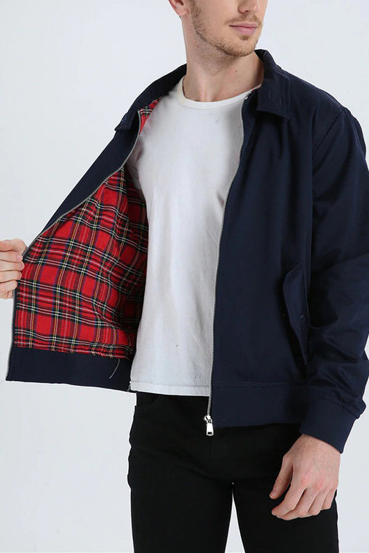 Mann trägt dunkelblaue Jacke mit rotem Karofutter, weißem T-Shirt und schwarzer Hose.