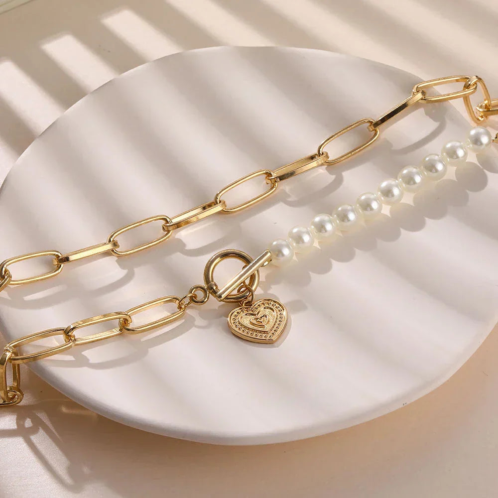 Goldene Halskette mit Herzanhänger und Perlen, modisches Schmuckstück für Damen.