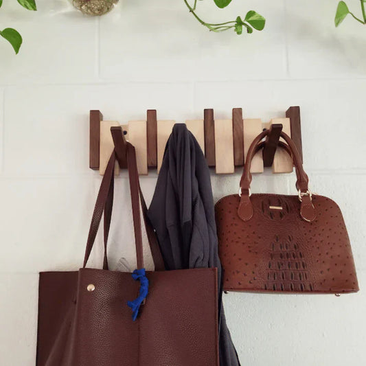 Holzgarderobe mit braunen Ledertaschen und grauem Schal, Wandmontage, modernes Design.