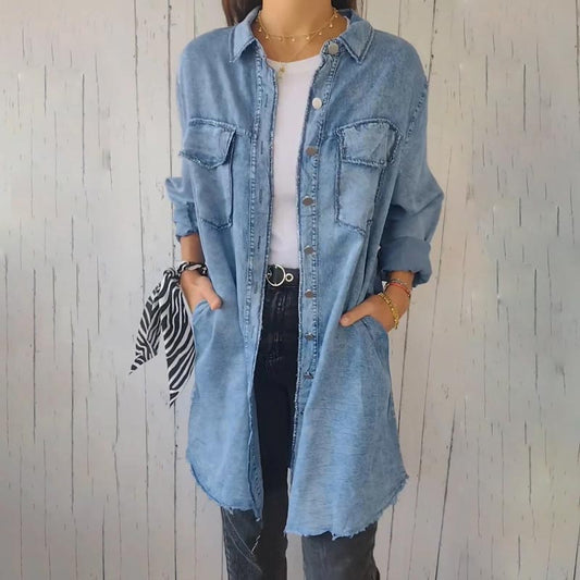Frau in langem, hellblauem Jeanshemd, weiße Bluse, schwarze Hose, lässiger Stil.