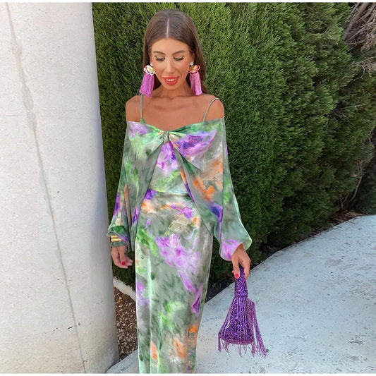 Frau in grünem, floralem Kleid mit lila Handtasche, elegante Mode, Sommeroutfit, draußen.