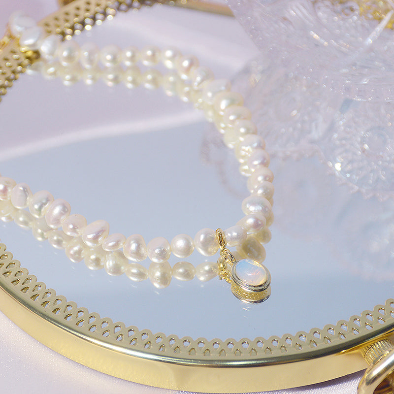 Imitationsperlen-Kurzhalskette mit blauem Schmetterlingsanhänger auf goldener Platte.