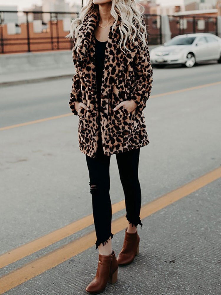 Frau in Leopardenmantel, schwarze Jeans, braune Stiefeletten, Stadtstraße, modisch, Herbstlook.