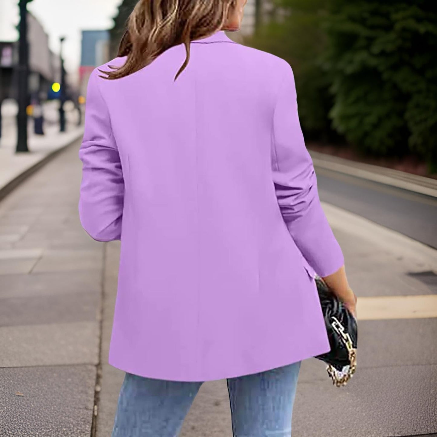Frau in lila Blazer, Jeans, schwarze Tasche, Stadtstraße, modischer Look, Damenmode.