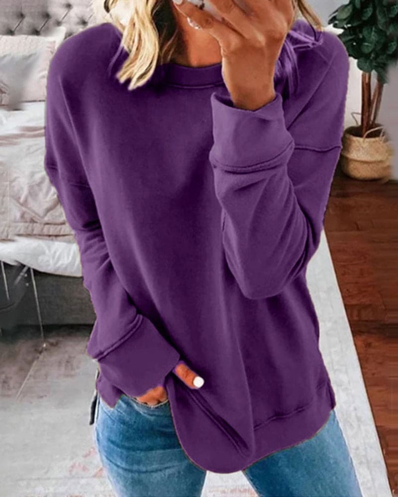 Frau in lila Pullover, lässig, gemütlich, modisch, Freizeitkleidung, Wohnzimmer, Jeans.