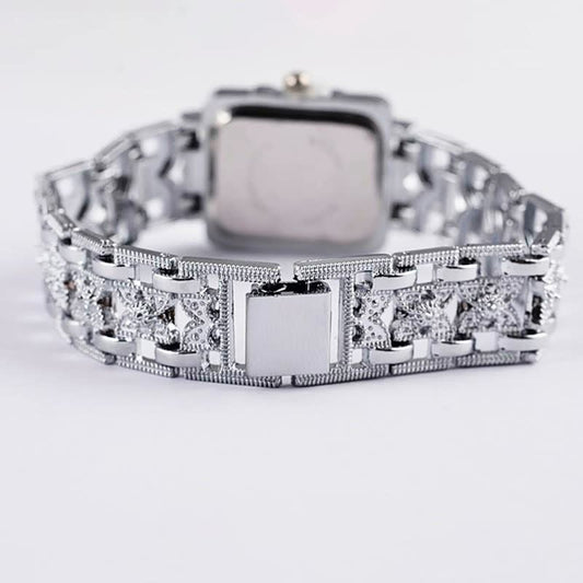 Silberne Armbanduhr mit quadratischem Zifferblatt und verziertem Gliederarmband, luxuriöses Design.
