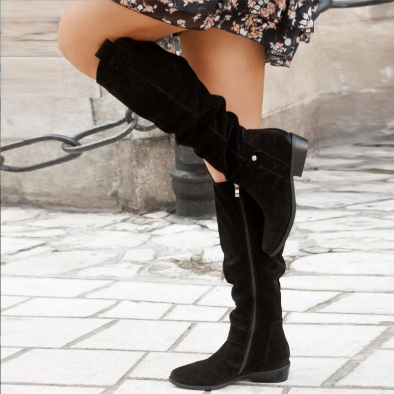 Frau trägt schwarze Wildlederstiefel, kniehoch, mit Reißverschluss, modisch, Herbstmode.