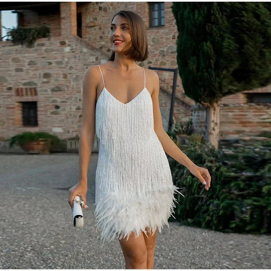 Frau im weißen Cocktailkleid mit Federn, elegantes Abendoutfit, draußen, stilvoll.