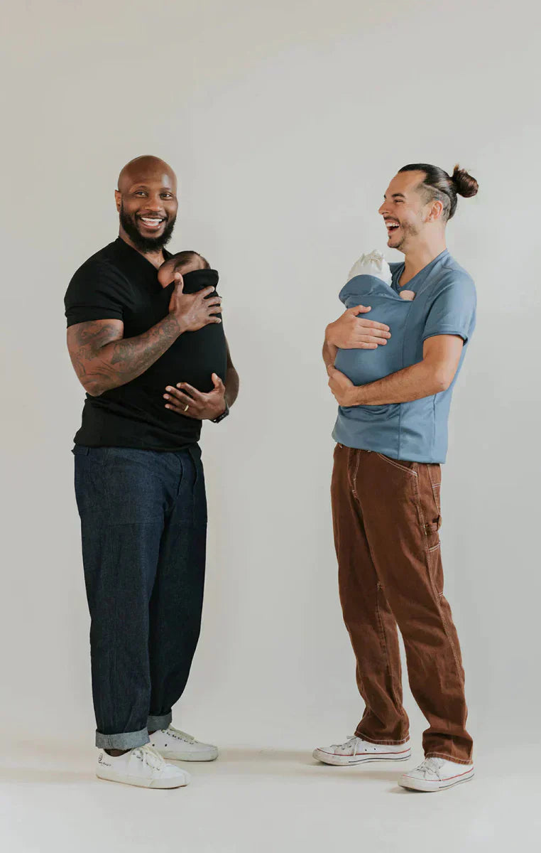 Zwei Männer tragen Babytragen-Shirts, schwarz und blau, lächelnd, lässige Kleidung.