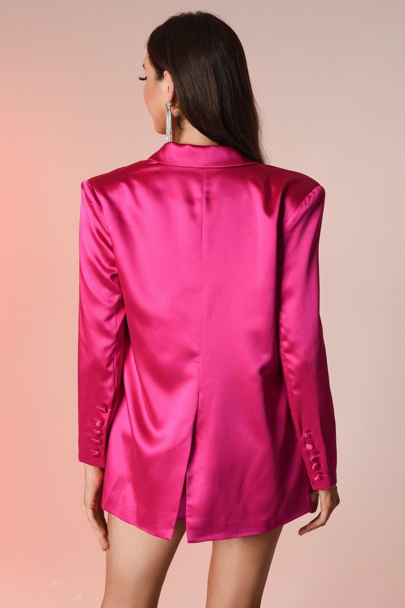 Frau in pinkem Satinblazer mit langen Ärmeln, eleganter Mode, Rückansicht.