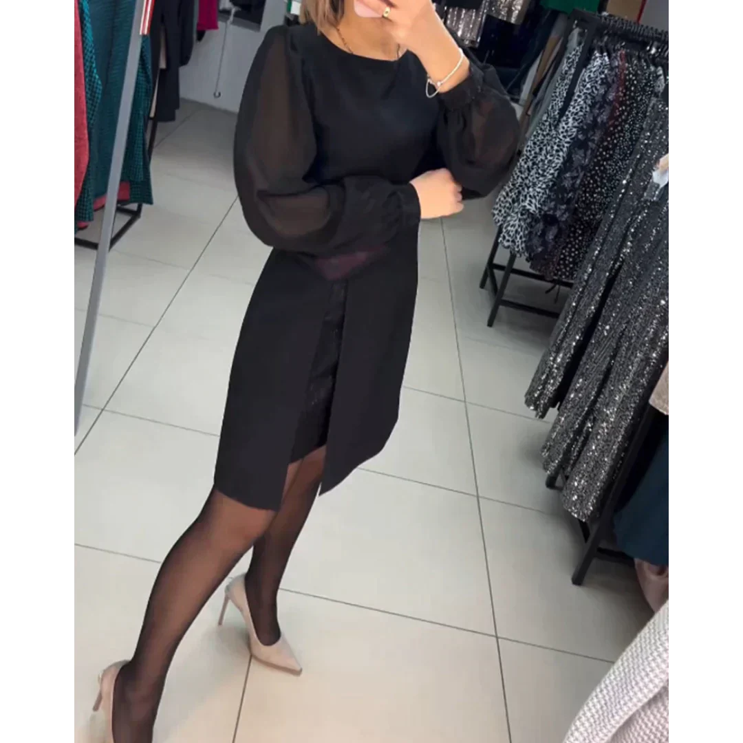 Frau in schwarzem Kleid mit langen Ärmeln, trägt schwarze Strumpfhose und beige Pumps im Modegeschäft.