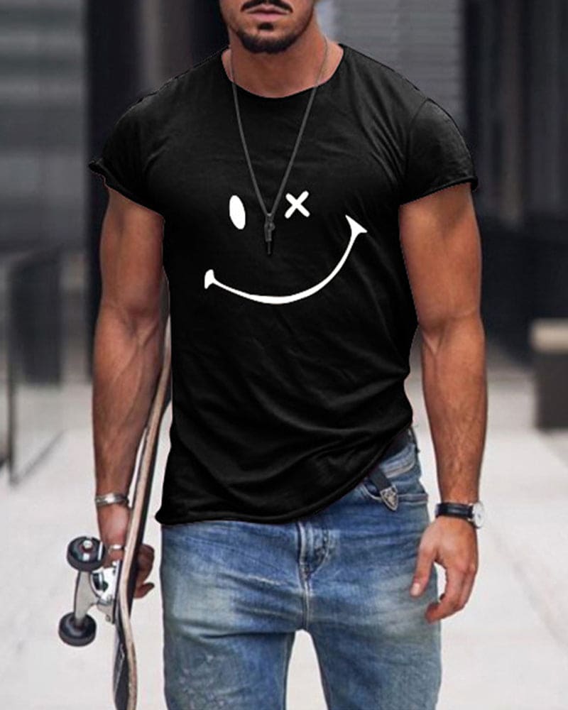 Mann in schwarzem T-Shirt mit Smiley-Design, Jeans, Skateboard, urbaner Hintergrund.