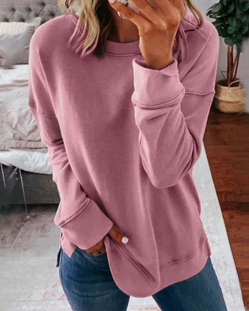 Frau in rosa Pullover, lässig, gemütlich, modisch, Freizeitkleidung, Wohnzimmer, Jeans.