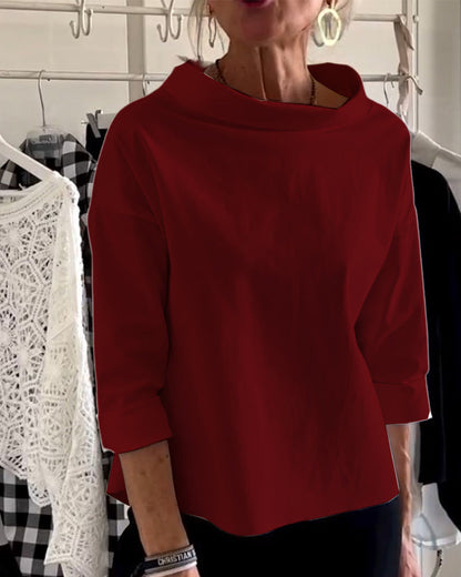 Frau in rotem Langarmshirt, lässig, modisch, vor Kleiderständer, elegante Damenmode.