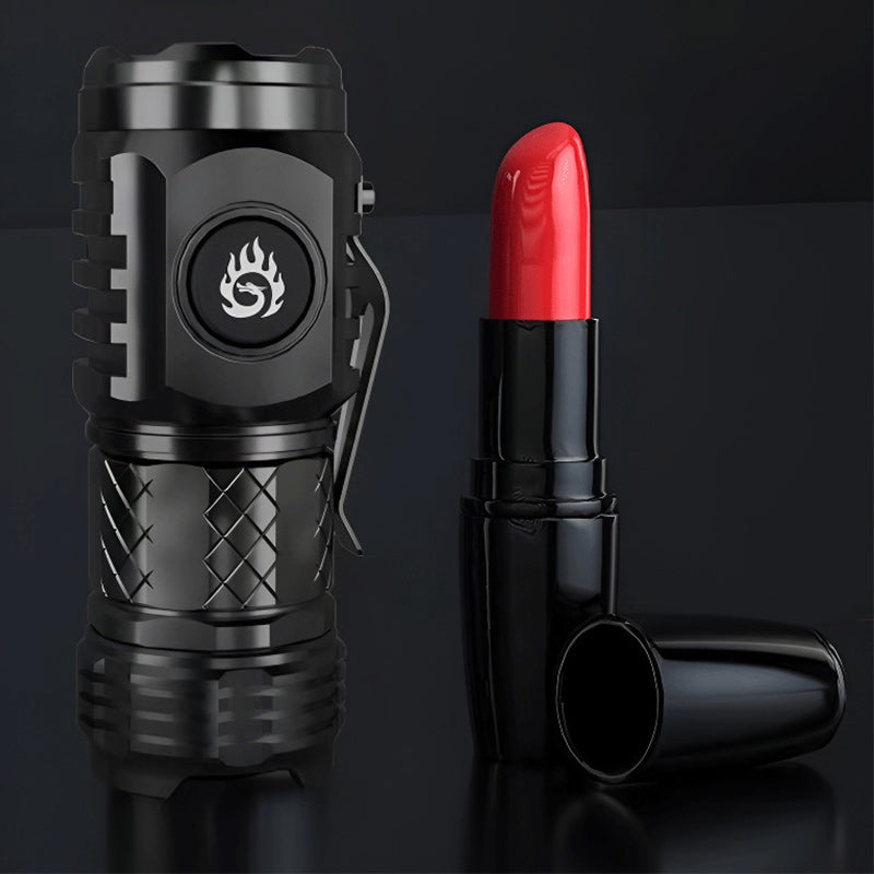 Schwarze Taschenlampe und roter Lippenstift auf schwarzem Hintergrund, modern und stilvoll.