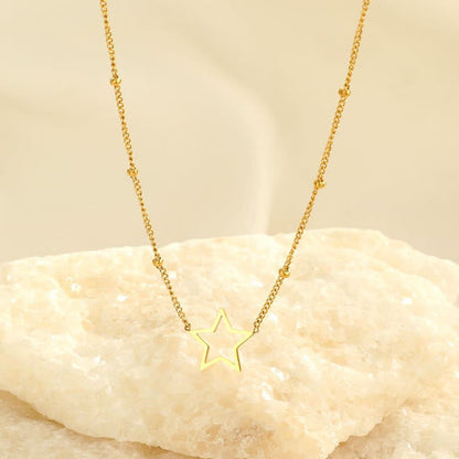 Goldene Stern-Halskette auf hellem Hintergrund, elegantes Schmuckdesign, modisches Accessoire.