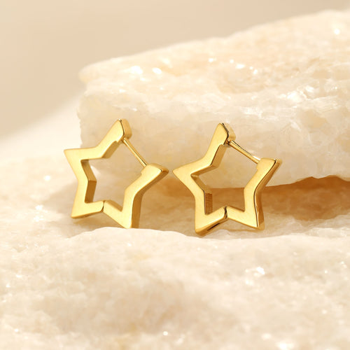 Goldene Stern-Ohrringe auf hellem Stein, modische Schmuckaccessoires für Damen.