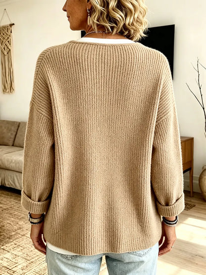 Baksidan av den beige ribbstickade koftan, med uppvikta ärmar, buren över vit topp och jeans 2