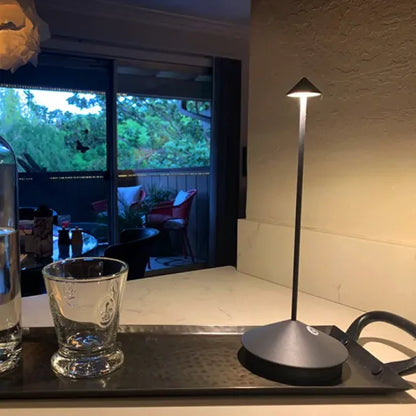 Moderne schwarze Tischlampe auf Küchentheke, LED-Beleuchtung, minimalistisches Design.