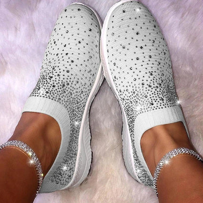 Weiße Damen-Sneaker mit Strasssteinen, bequem, modisch, auf flauschigem Teppich.