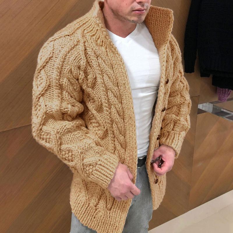 Mann trägt beige Strickjacke mit Zopfmuster, Holzknöpfen, über weißem T-Shirt, modisch, warm.