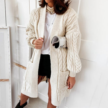 Frau trägt cremefarbenen Strickcardigan, Zopfmuster, lässig, modisch, Herbstmode, Damenbekleidung.