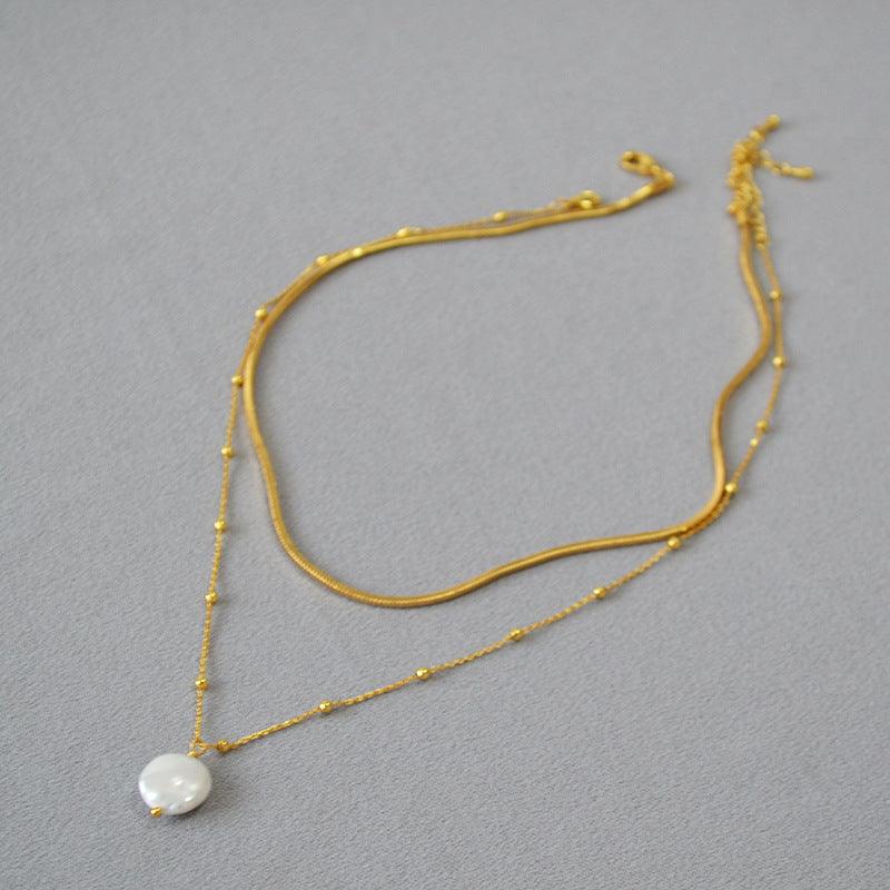 Goldene Halskette mit Perlenanhänger, elegantes Schmuckdesign, Damenaccessoire.