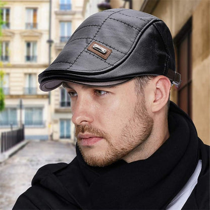 Mann mit schwarzer Leder-Schiebermütze, gesteppt, modisch, urbaner Hintergrund.