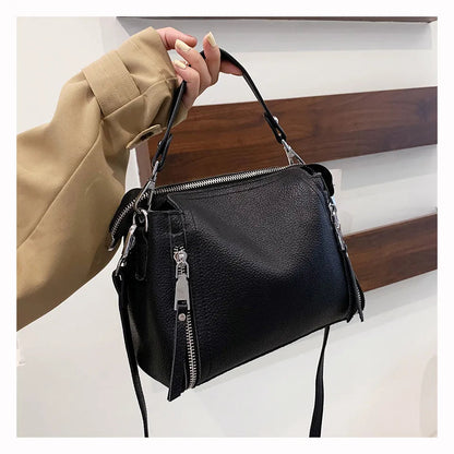 Schwarze Lederhandtasche mit Reißverschlüssen, Damenmode, elegantes Accessoire.