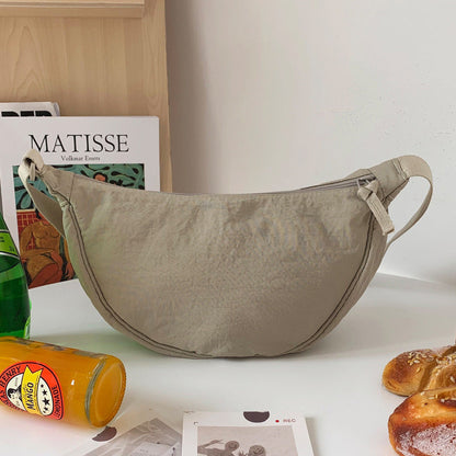 Beigefarbene Umhängetasche aus Stoff auf Tisch, modisch, praktisch, ideal für den Alltag.