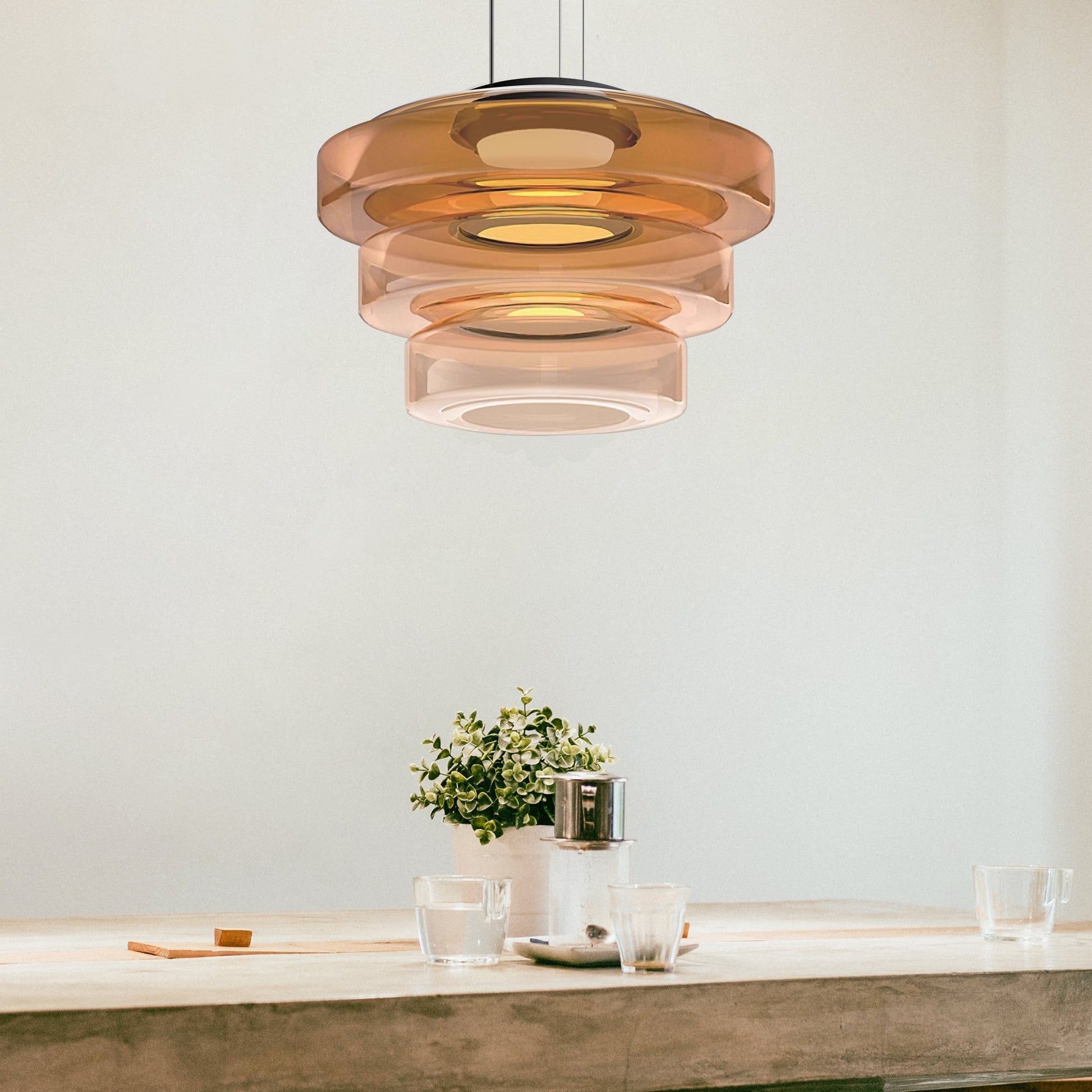 Moderne Pendelleuchte aus Glas in Braun über Esstisch, skandinavisches Design.