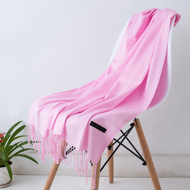 Rosa Kaschmirschal auf weißem Stuhl, weiches Material, modisches Accessoire, Wohnzimmerdekor.