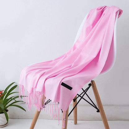 Rosa Kaschmirschal auf weißem Stuhl, weiches Material, modisches Accessoire, Wohnzimmerdekor.