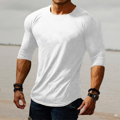 Mann in weißem Langarmshirt am Strand, muskulös, modisch, Freizeitkleidung, Herrenmode.