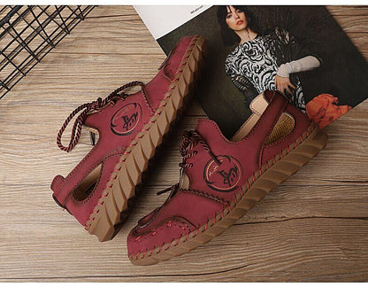 Rote Damen-Ledersandalen mit Schnürung, rutschfeste Sohle, lässiger Stil, auf Holzboden.