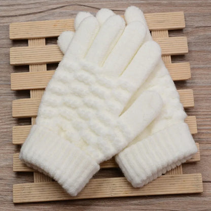 Weiße gestrickte Winterhandschuhe aus Wolle auf Holzunterlage, warm und stilvoll.