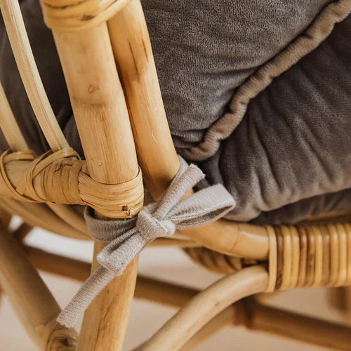 Rattan-Stuhl mit grauem Kissen, Nahaufnahme, handgefertigt, skandinavisches Design.