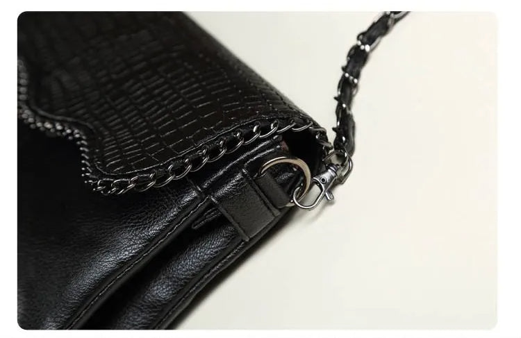 Schwarze Lederhandtasche mit Krokodilprägung und Kettendetail, elegant und modisch.
