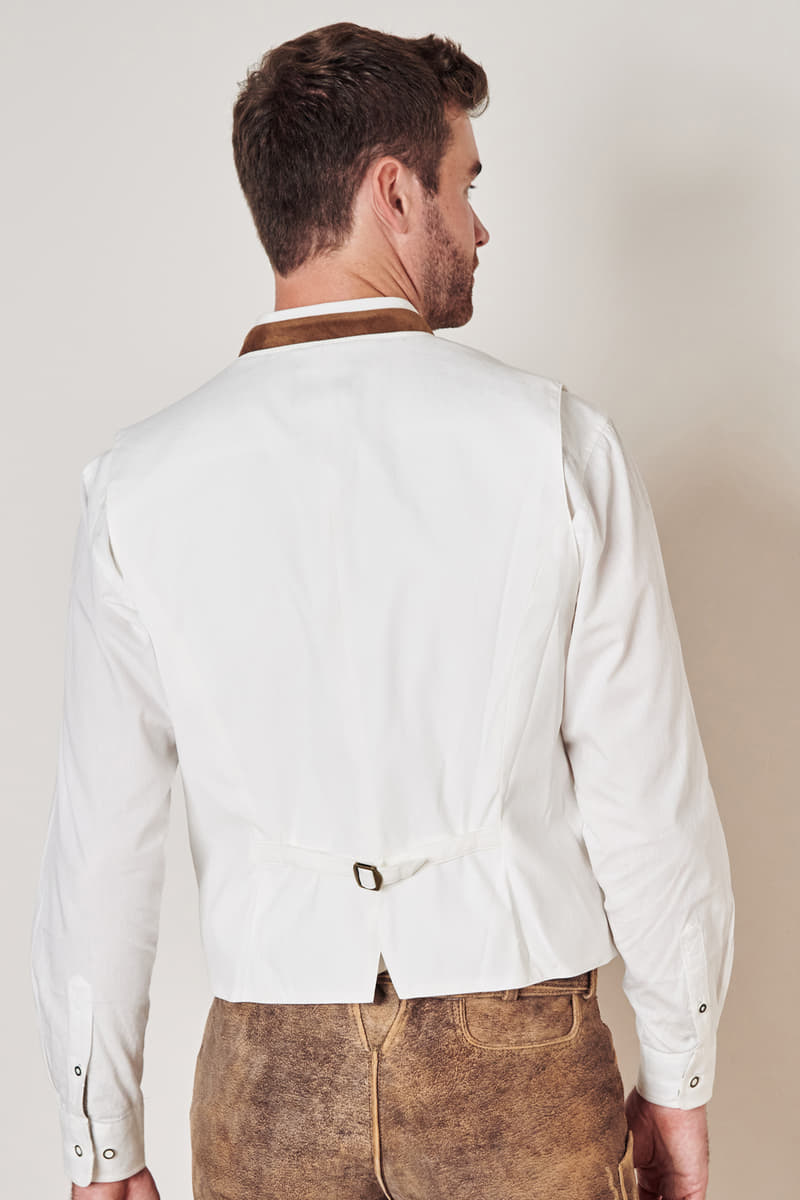 Mann in weißer Trachtenweste und brauner Lederhose, Rückansicht, traditionelles bayerisches Outfit.