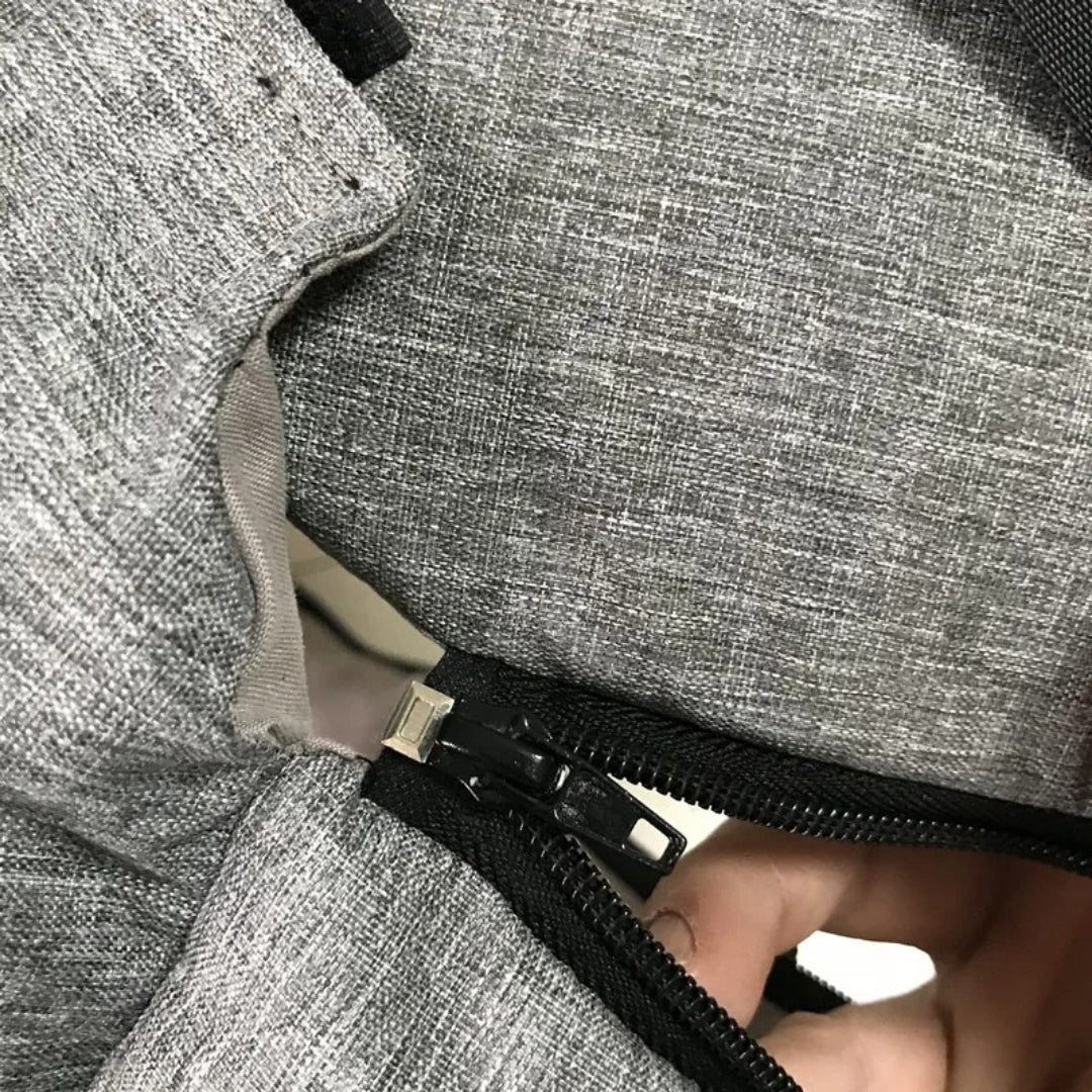 Grauer Rucksack mit Reißverschluss, strapazierfähiges Material, ideal für Reisen und Alltag.
