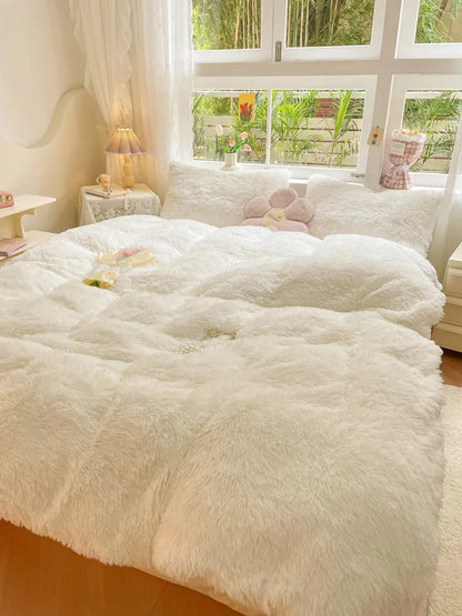 Gemütliches Schlafzimmer mit weißem, flauschigem Bettbezug, Kissen und Dekorationen.
