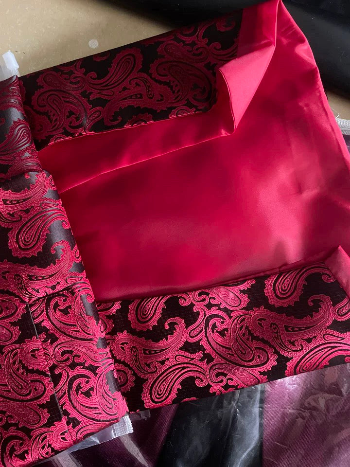 Roter Brokatstoff mit Paisley-Muster, ideal für elegante Kleidung und Dekoration.