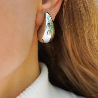 Silberne Tropfen-Ohrringe, glänzend, modern, elegantes Design, Damenmode, Schmuckaccessoire.