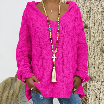 Frau in pinkem Strickpullover mit Kapuze, bunte Halskette, lässiger Stil, modisch.