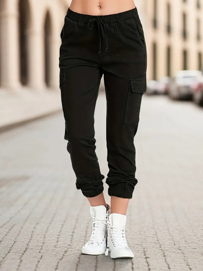 Schwarze Damen-Cargohose, elastischer Bund, Seitentaschen, lässiger Stil, Straßenhintergrund.
