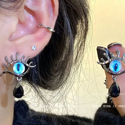 Silberne Ohrringe mit blauem Auge und schwarzem Tropfenanhänger, modisches Accessoire.