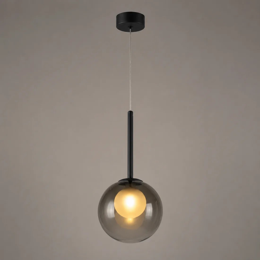 Tänd rökgrå glasklotslampa med svart stav, fotograferad mot en gråbrun bakgrund 10