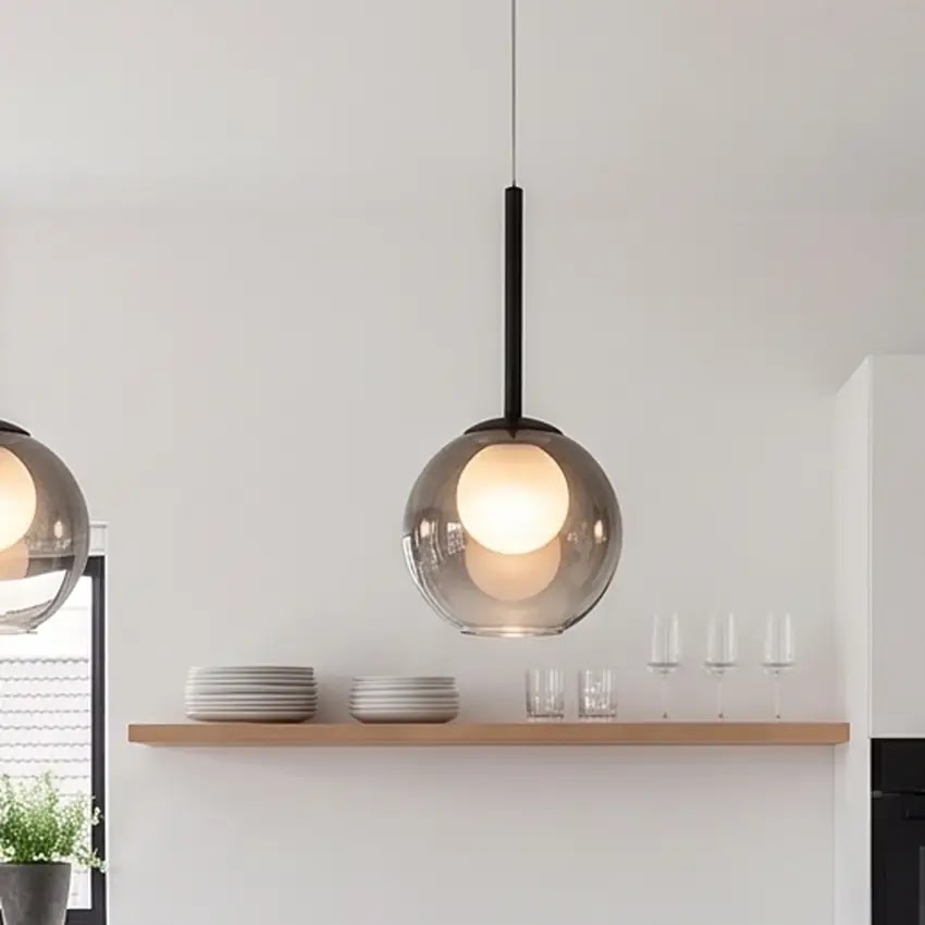 Närbild på rökgrå glaslampa med svart stav som hänger ovanför en hylla med tallrikar och glas 11
